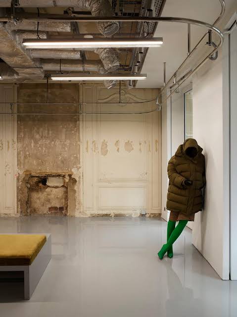 Hooded figure in a puffer coat against the wall, Balenciaga